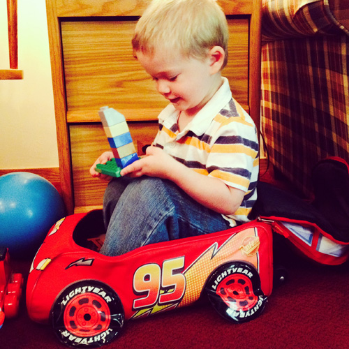 We bought this Cars suitcase at a garage sale for $1.50. It's been perfect to store Wesley's toys and he can wheel it around himself. Apparently, Wes has discovered another use for it!